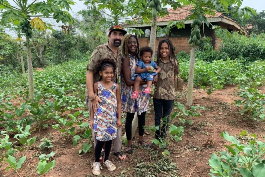 Isaac Hirt Manheimer and wife Ewoenam who founded the UnityEco Village pose among lush greenery with their three young children