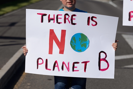 Person holding sign that says There is No Planet B