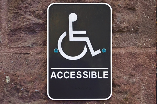 wheelchair accessible sign hanging on a wall